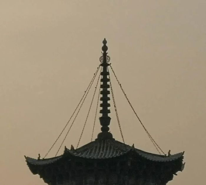 从泉州1915艺术空间二楼看见的塔顶，塔身被龙眼树遮住，只能看见塔顶尖端.jpg